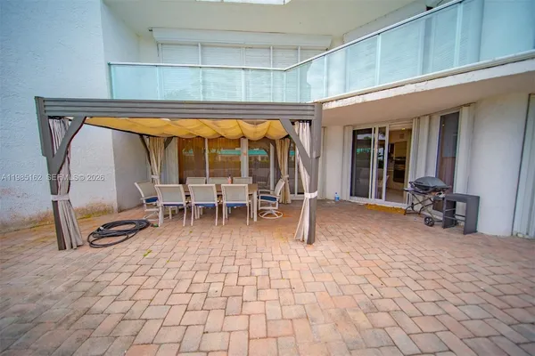a view of a patio with table and chairs and potted plants