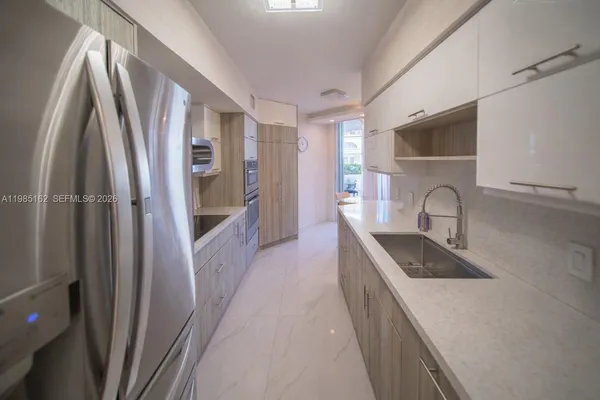 a kitchen with stainless steel appliances kitchen island granite countertop a refrigerator and a stove top oven