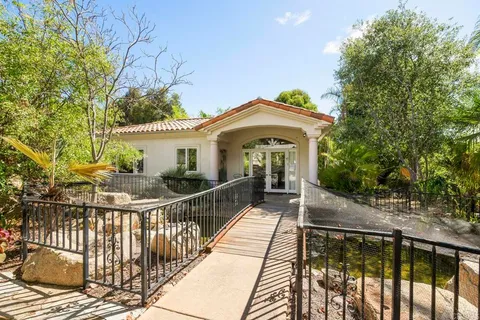 a view of a house with a yard and palm trees