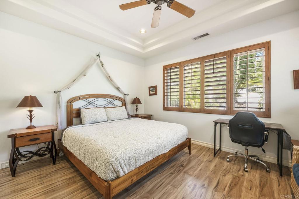 15615 Boulder Ridge Lane Poway, CA 92064 - Photo 49 of 75 a bedroom with a bed a chair and a chandelier