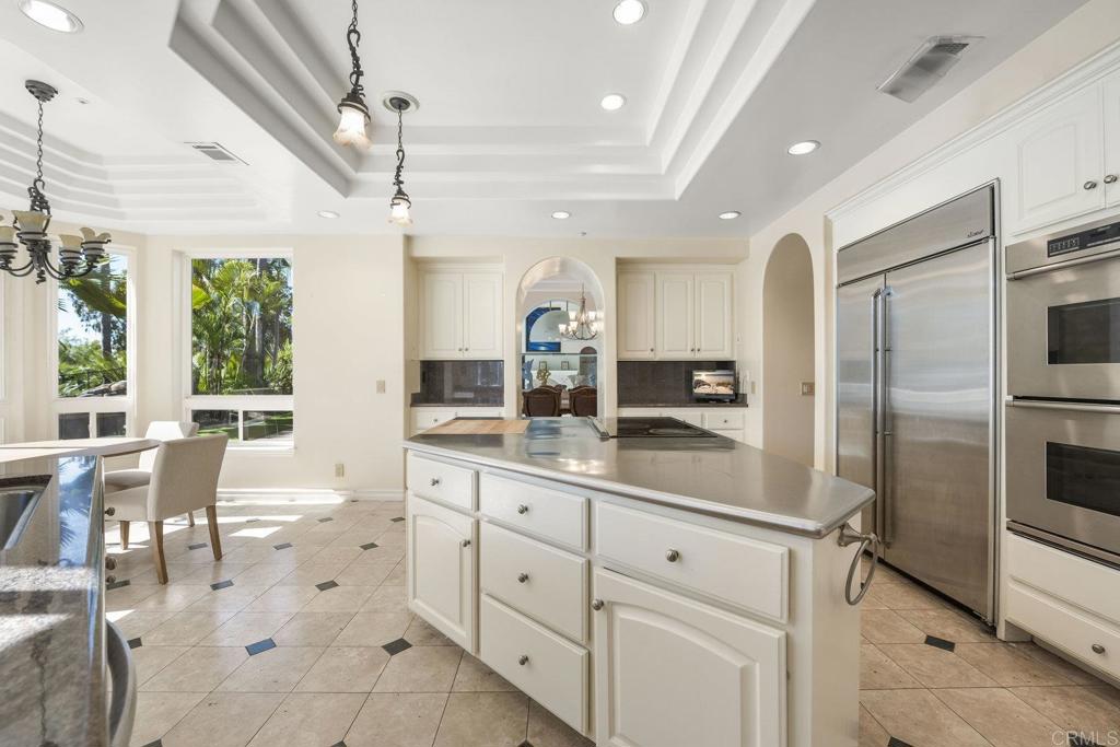15615 Boulder Ridge Lane Poway, CA 92064 - Photo 10 of 75 a kitchen with stainless steel appliances kitchen island granite countertop a refrigerator and cabinets