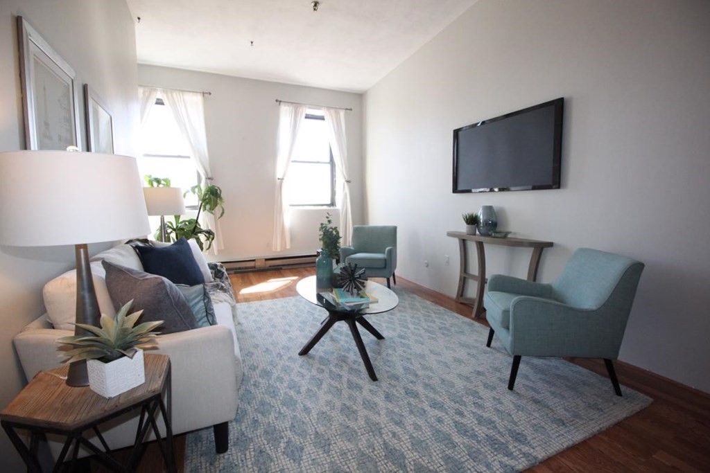 a living room with furniture wooden floor and a flat screen tv