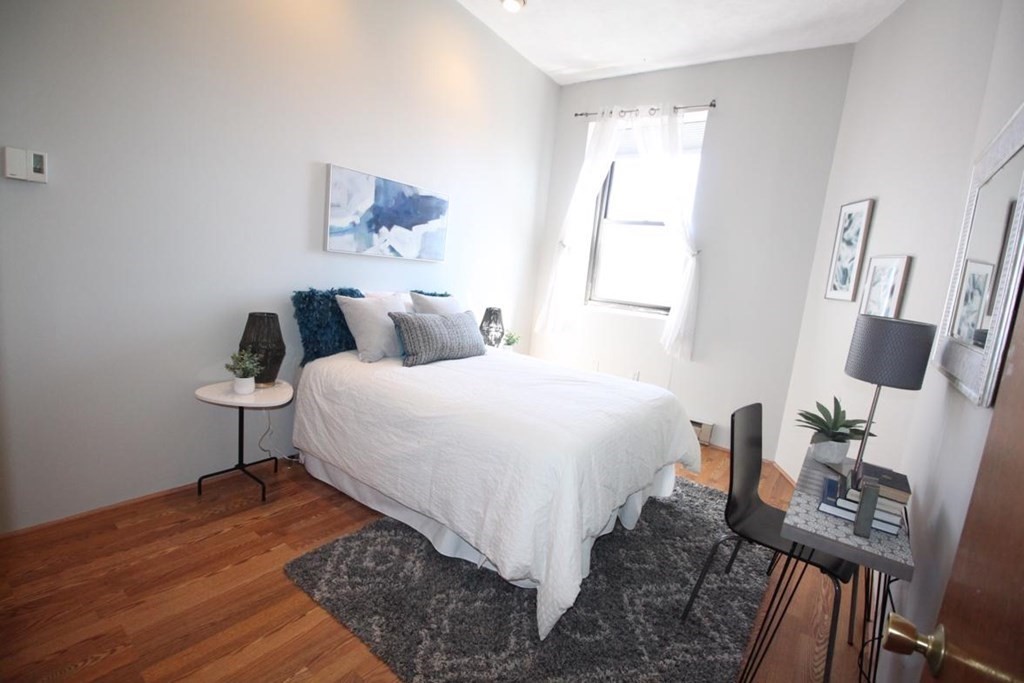 3 Appleton Street, Unit 502 Boston, MA 02116 - Photo 9 of 14 a bedroom with a bed a chair and a potted plant on the dresser