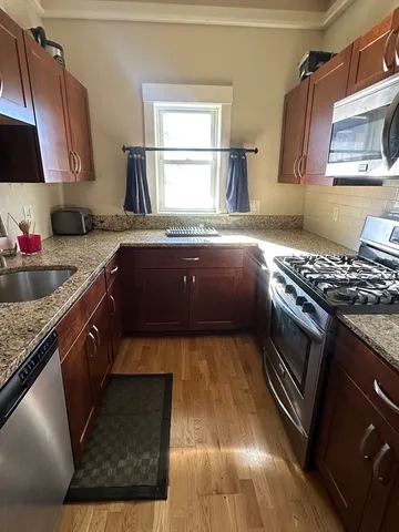 a kitchen with kitchen island granite countertop a stove a sink and a microwave