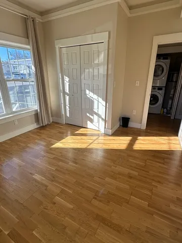a view of an empty room with window and a kitchen