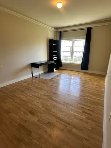 a view of an empty room with a window and a fireplace