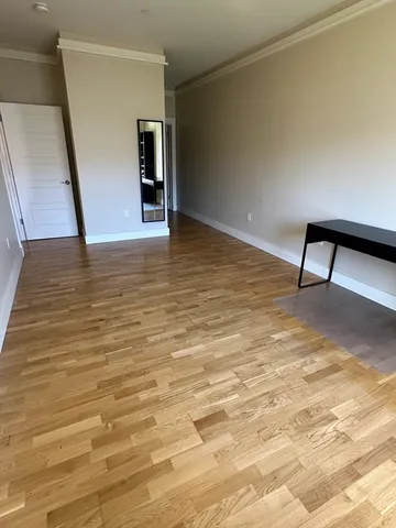 a view of empty room with wooden floor