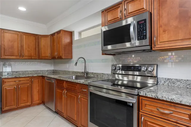 a kitchen with stainless steel appliances granite countertop a stove microwave and oven