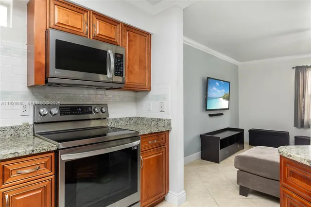 a kitchen with stainless steel appliances granite countertop a stove top oven microwave and refrigerator