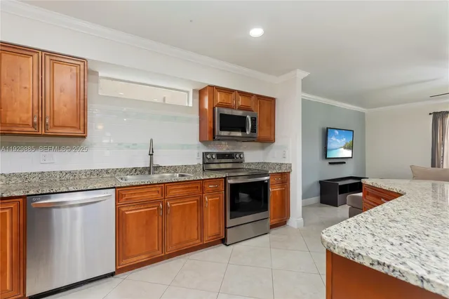 a kitchen with stainless steel appliances granite countertop a stove a sink a microwave a refrigerator and chairs