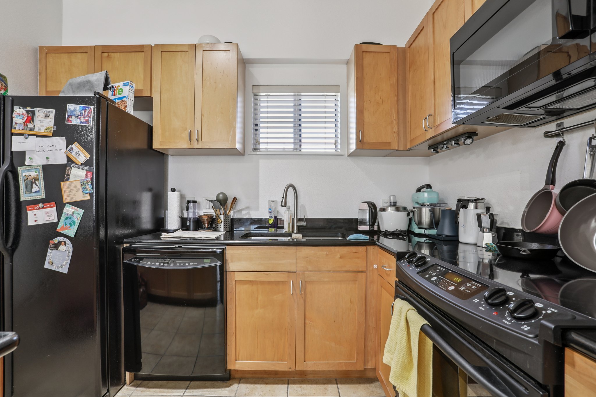 711 West 26th Street, Unit 704 Austin, TX 78705 - Photo 16 of 32 a kitchen with stainless steel appliances granite countertop a stove a sink and a microwave