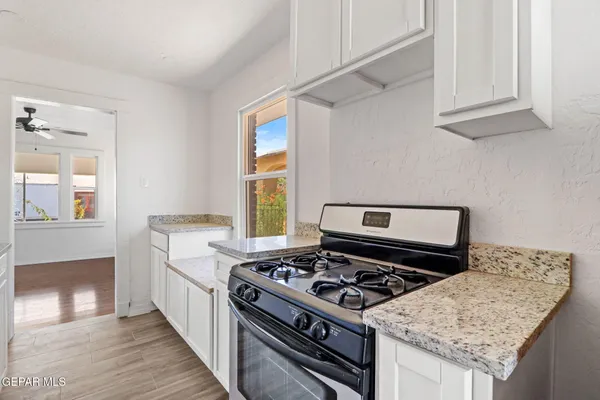 a kitchen with granite countertop a stove and a sink