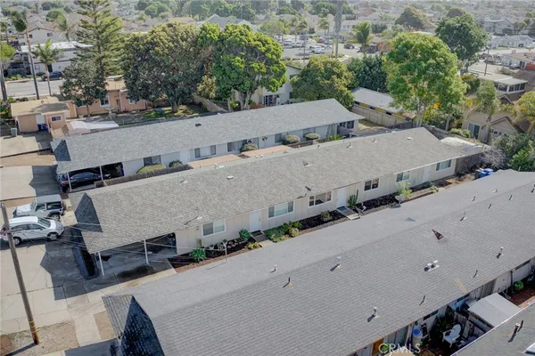 an aerial view of a house with a yard and mountain view in back