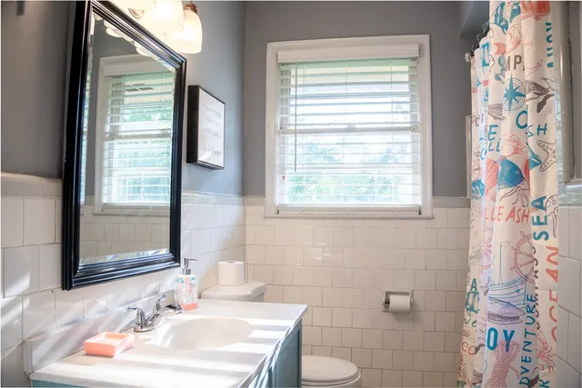 a bathroom with a sink a toilet and a mirror