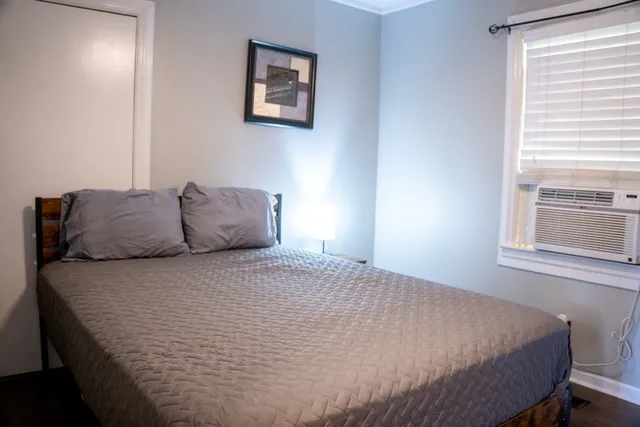 a bedroom with a bed and windows