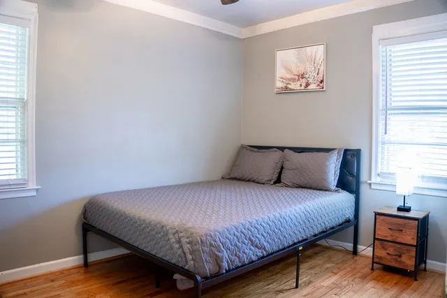 a bedroom with a bed and wooden floor