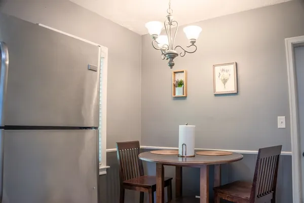 a view of a dining room with furniture a chandelier and wooden floor