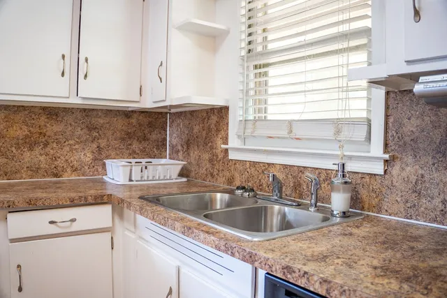 a kitchen with granite countertop a sink and a window
