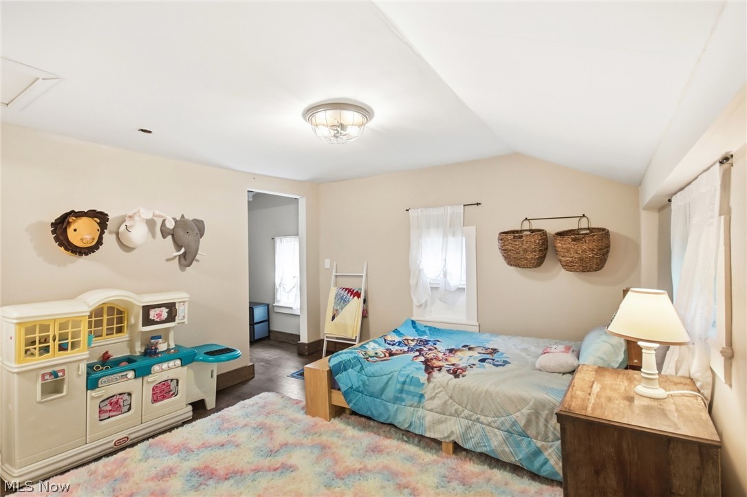2591 Wayland Road Deerfield, OH 44411 - Photo 23 of 46 Bedroom featuring an angled ceiling, two windows with white curtains, and a ceiling-mounted light fixture