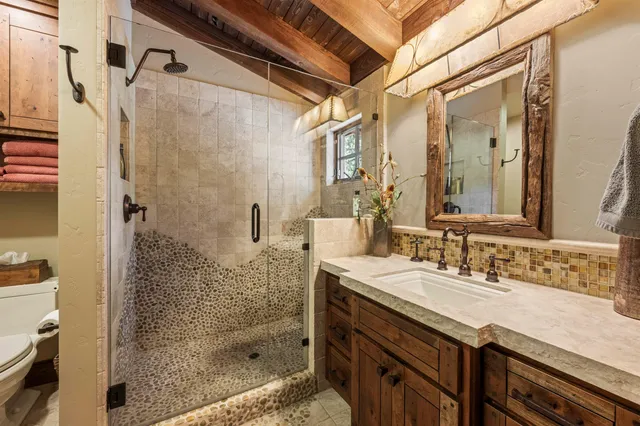 a bathroom with a granite countertop shower a sink and a mirror