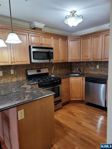 a kitchen with stainless steel appliances granite countertop a stove a sink and a microwave