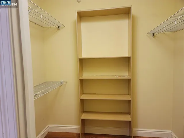 a view of walk in closet with empty racks
