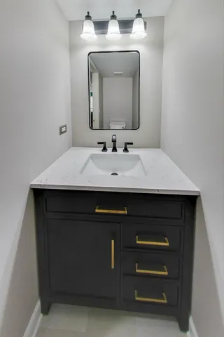 a bathroom with a sink vanity and a mirror