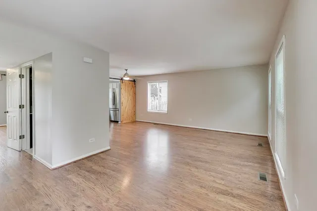 an empty room with wooden floor and window