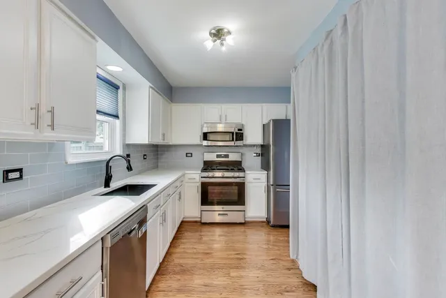 a kitchen with granite countertop a sink stove and microwave