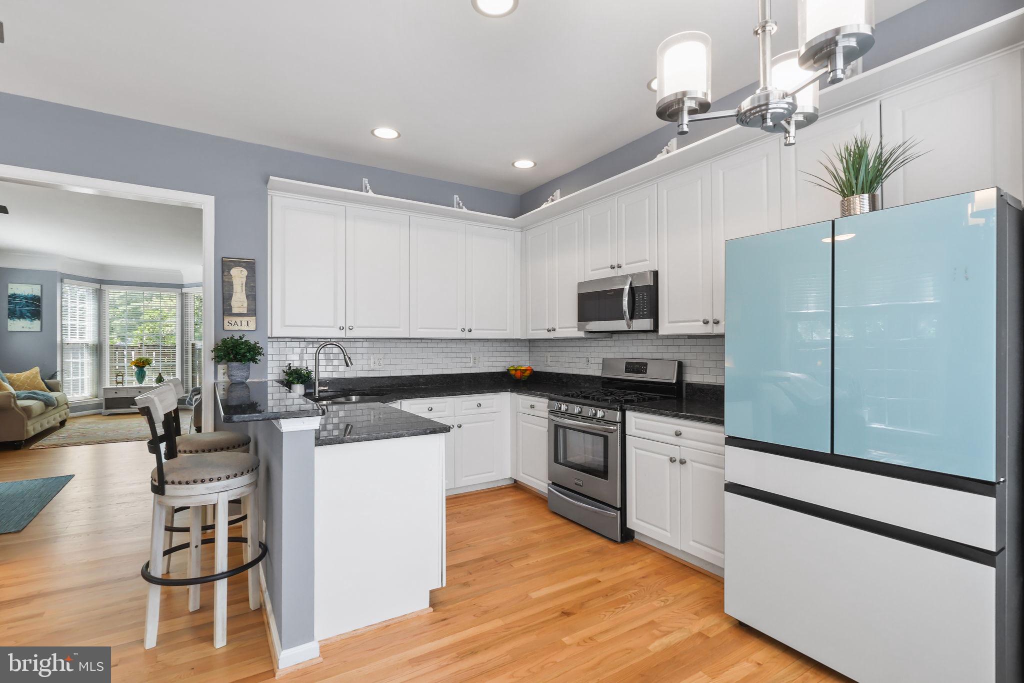 6038 Lincolnia Road Alexandria, VA 22312 - Photo 9 of 31 a kitchen with a refrigerator a stove cabinets and living room view