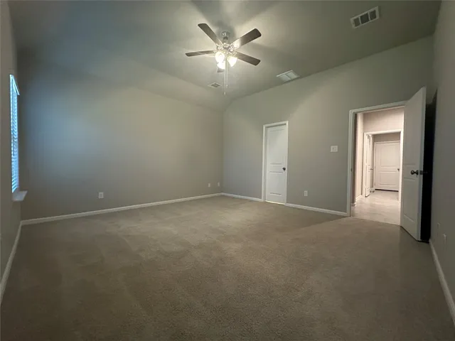 a view of a room with a ceiling fan and window