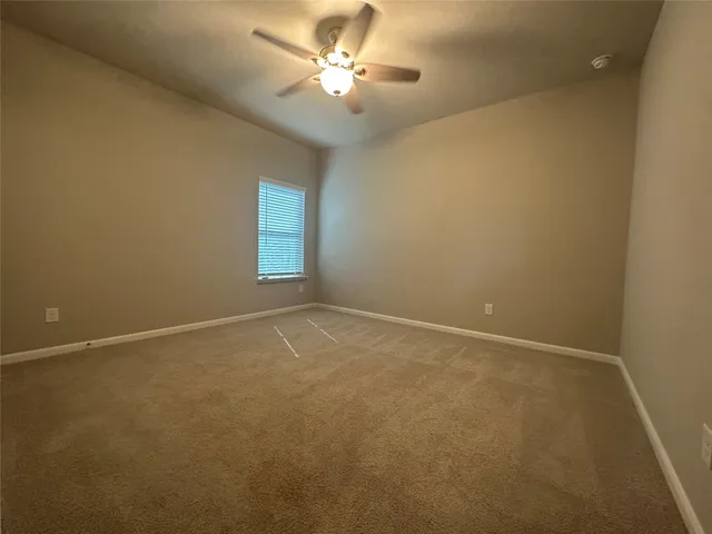 an empty room and a chandelier fan