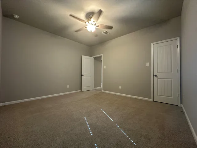a view of an empty room with a chandelier fan