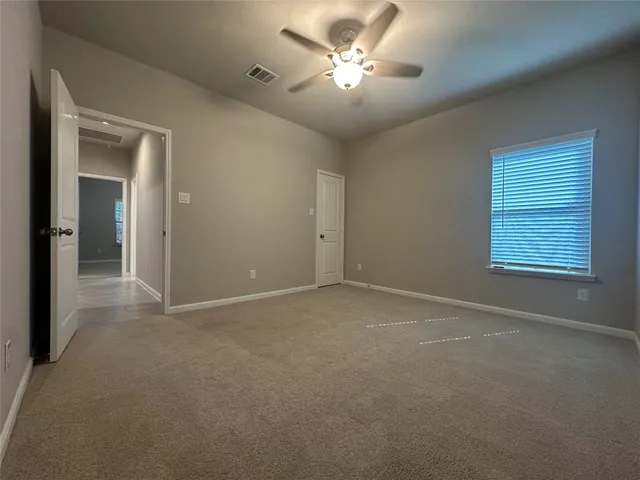 an empty room with a window and a ceiling fan