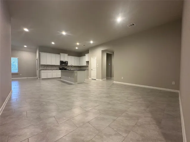 a view of kitchen with refrigerator and chairs