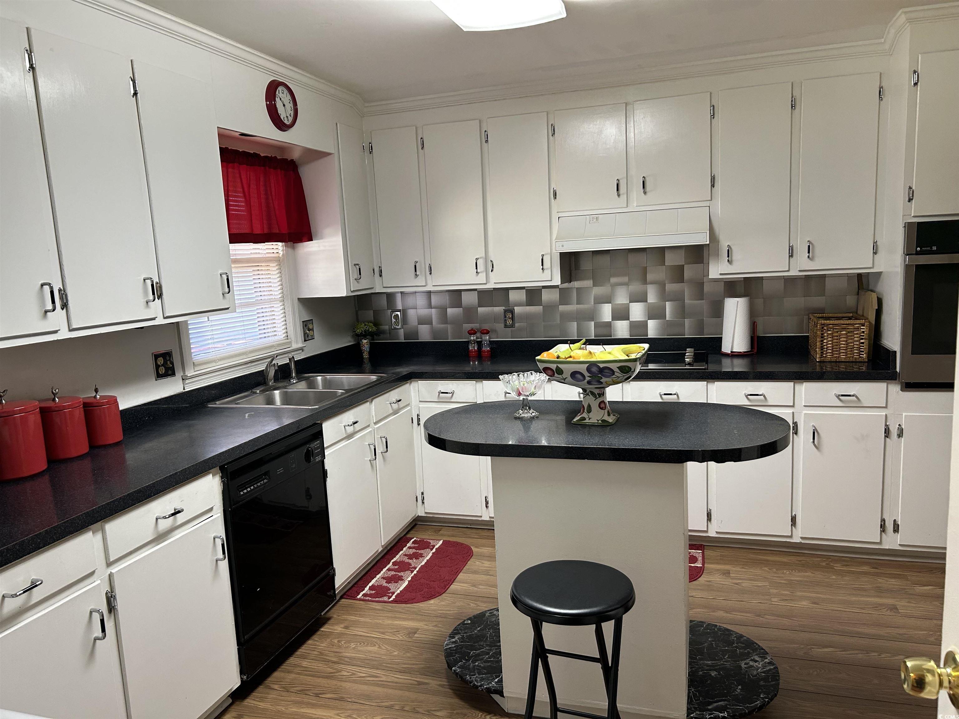 1411 East Harrison Street Dillon, SC 29536 - Photo 12 of 40 Kitchen with dark countertops, tasteful backsplash, white cabinetry, dishwasher, and oven