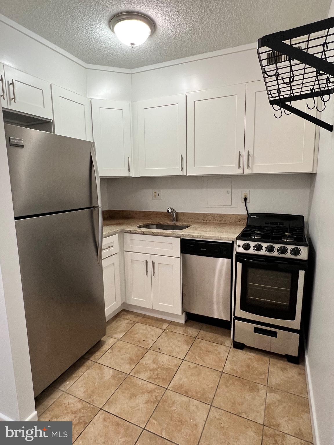 a kitchen with a stove a refrigerator and cabinets