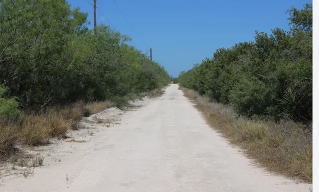 a view of a dirt road with a building in the background
