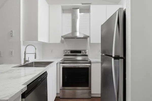 a kitchen with stainless steel appliances granite countertop a stove and a refrigerator