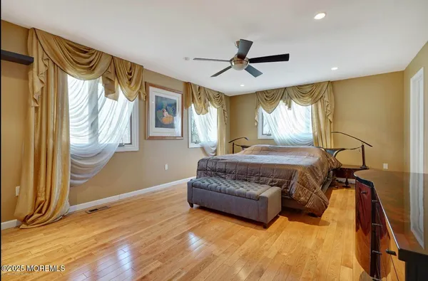 a spacious bedroom with a bed mirror and a window
