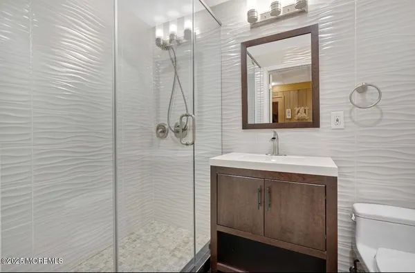 a bathroom with a sink a toilet and shower