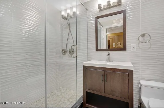 a bathroom with a sink a toilet and shower