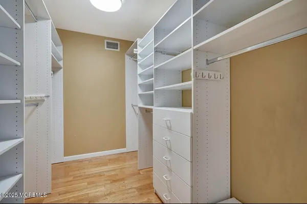a view of walk in closet with empty racks