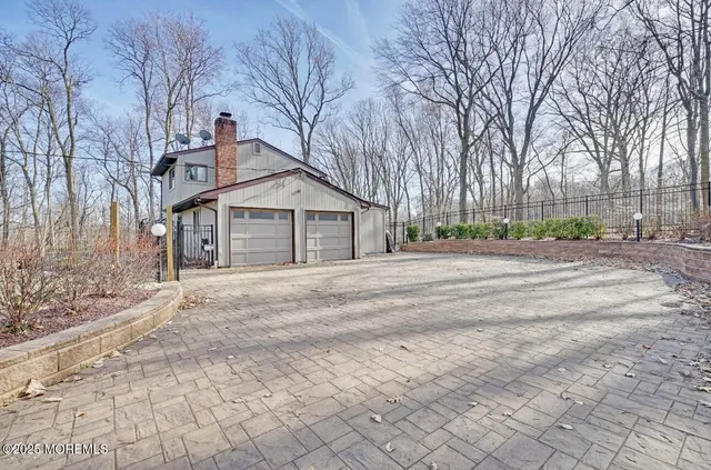 a front view of a house with a yard and large trees