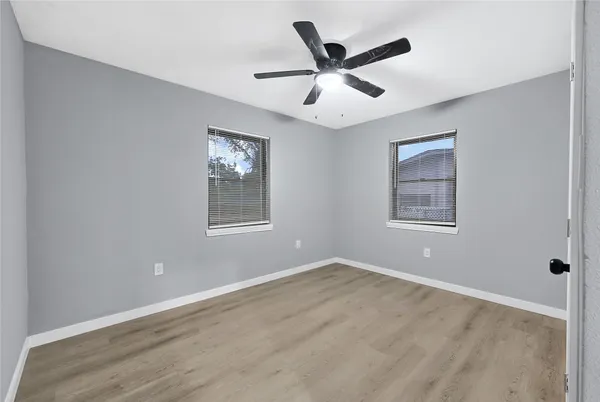 a view of a big room with wooden floor and windows