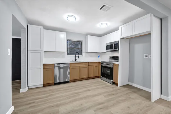 a kitchen with a white cabinets and white appliances