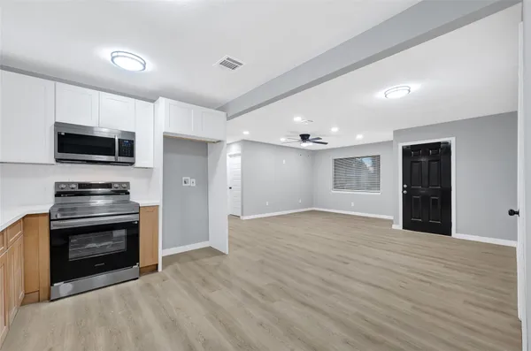 a view of kitchen with microwave stove and cabinets