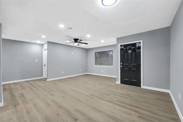 a view of an empty room with wooden floor