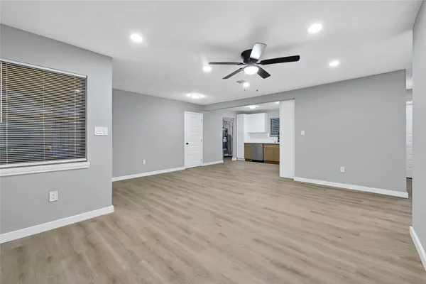 a view of empty room with wooden floor and window