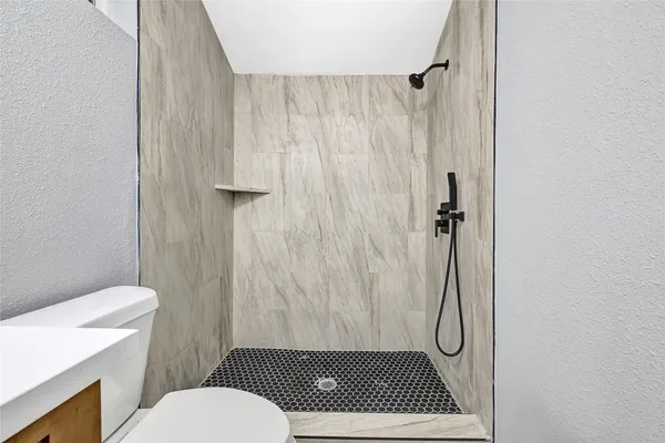 a bathroom with a toilet and a shower